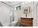 Modern bathroom features a tiled shower, sleek vanity with a round mirror, and a window for natural light at 7476 Park Lane Rd, Longmont, CO 80503