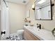 Bright bathroom featuring a wide vanity, skylight, and black-framed mirror at 7476 Park Lane Rd, Longmont, CO 80503