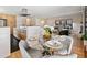 Stylish dining area flowing from the kitchen featuring a glass table, hardwood floors, and a view to the living room at 7476 Park Lane Rd, Longmont, CO 80503