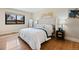 Bright main bedroom features a large bed, wood floors, neutral walls, and a window at 7476 Park Lane Rd, Longmont, CO 80503