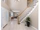 Inviting foyer featuring tile flooring, staircase, and a view into a cozy living room at 18003 E Alamo Dr, Centennial, CO 80015