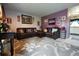 Cozy living room featuring comfortable leather furniture, a patterned rug, and a purple accent wall at 19258 E Kansas Dr, Aurora, CO 80017