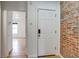 Entryway with a white door, exposed brick wall, leading into a light-filled living area at 2306 Glenarm Pl # 206, Denver, CO 80205