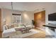 Cozy living room featuring a large sectional sofa, wood floors, exposed brick, and ample natural light at 2306 Glenarm Pl # 206, Denver, CO 80205