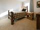 Bedroom featuring wood-frame twin bed, carpet flooring, and a rustic end table with storage at 5973 S Krameria St, Centennial, CO 80111
