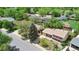 A beautiful home featuring mature landscaping with lush greenery, a tidy lawn, and red shutters at 2453 S Memphis Way, Aurora, CO 80013