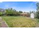 A lovely backyard featuring an expansive lawn, a wooden fence, mature trees, and a convenient shed at 2453 S Memphis Way, Aurora, CO 80013