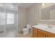 Bright bathroom features a wood vanity, white countertops, toilet, and shower stall with glass door at 2453 S Memphis Way, Aurora, CO 80013