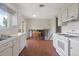 Well-lit kitchen featuring classic white cabinets, modern appliances, and a view of the living room at 2453 S Memphis Way, Aurora, CO 80013