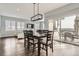 Elegant dining area adjacent to the living room with a modern light fixture and sliding glass doors at 14734 Domino Dr, Parker, CO 80134