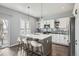 Stylish kitchen featuring a central island with seating, white cabinetry, and modern lighting fixtures at 14734 Domino Dr, Parker, CO 80134