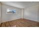Bedroom featuring hardwood floors and white brick accent wall with a window at 6800 E Tennessee Ave # 533, Denver, CO 80224