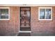 A brick facade with secure black iron door and surrounding windows provides a classic look to the home's entrance at 6800 E Tennessee Ave # 533, Denver, CO 80224