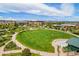 Aerial view of a park with a large grassy field, playground, and amphitheater for community events at 1144 Rockhurst Dr # 105, Highlands Ranch, CO 80129