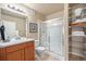 Bathroom featuring a glass shower, ample shelving for storage, and a granite vanity at 1144 Rockhurst Dr # 105, Highlands Ranch, CO 80129