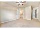Bright bedroom with ceiling fan, neutral walls, carpet, and entry to a walk in closet at 1144 Rockhurst Dr # 105, Highlands Ranch, CO 80129