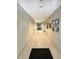 Long hallway with neutral walls, tiled floor, and artwork at 1144 Rockhurst Dr # 105, Highlands Ranch, CO 80129