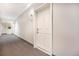 Hallway with carpet and a white entry door to a condo unit at 1144 Rockhurst Dr # 105, Highlands Ranch, CO 80129