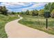 Walking trail in a neighborhood, featuring a paved pathway, mature trees, and scenic views at 1144 Rockhurst Dr # 105, Highlands Ranch, CO 80129