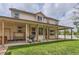 Rear exterior featuring a covered patio, hot tub, and large manicured lawn at 5483 Gunnison Dr, Frederick, CO 80504