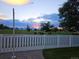 Backyard sunset view over the mountains and neighborhood, seen from behind the white picket fence at 5483 Gunnison Dr, Frederick, CO 80504