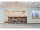 Basement stone bar featuring a wooden countertop and custom lighting at 5483 Gunnison Dr, Frederick, CO 80504