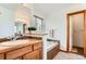 Bathroom featuring wood cabinets, an undermount tub, and decorative tile, ready for relaxation at 5483 Gunnison Dr, Frederick, CO 80504