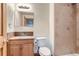 Bathroom featuring a neutral-toned shower, wooden cabinets, and modern fixtures at 5483 Gunnison Dr, Frederick, CO 80504