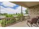 View from the covered front porch, showcasing outdoor seating and a glimpse of the surrounding green space at 5483 Gunnison Dr, Frederick, CO 80504