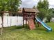 Playground set featuring a swing set, slide, and climbing wall in fenced backyard at 5483 Gunnison Dr, Frederick, CO 80504