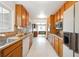 Galley kitchen featuring wood cabinets, appliances, and a view to the dining area at 10150 Melody Dr, Northglenn, CO 80260