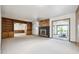 Spacious living room with a fireplace, built-in shelves, and sliding glass doors at 10150 Melody Dr, Northglenn, CO 80260