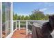 View of a wood deck with a black Traeger smoker grill overlooking the trees and lawn at 19157 E Progress Ave, Centennial, CO 80015