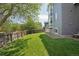 Spacious backyard with lush lawn, mature trees, wood fence, and gray siding on the home at 19157 E Progress Ave, Centennial, CO 80015