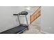 Finished basement area with access to wooden staircase, tile floors and a treadmill for home exercise at 19157 E Progress Ave, Centennial, CO 80015