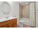 Bathroom featuring a bath tub and shower with tile surround, wood vanity, and a circular mirror at 19157 E Progress Ave, Centennial, CO 80015