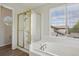 Bathroom featuring bathtub with glass shower, and large window at 19157 E Progress Ave, Centennial, CO 80015