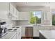 Bright kitchen featuring white cabinets, stainless steel appliances, and a large window, offering a clean cooking space at 19157 E Progress Ave, Centennial, CO 80015