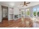 Open-concept living room with fireplace, large windows, hardwood floors and neutral paint at 19157 E Progress Ave, Centennial, CO 80015