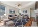 Virtually staged living room boasts hard wood floors, two sofas, two chairs, and a large window at 19157 E Progress Ave, Centennial, CO 80015