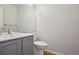 Well lit powder room featuring a grey vanity, a large mirror, and wood flooring at 19157 E Progress Ave, Centennial, CO 80015