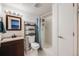 Bathroom featuring a shower-tub combo, storage shelving, and wood-look vanity at 9377 Weeping Willow Ct, Highlands Ranch, CO 80130