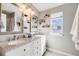 Bright bathroom showcasing a double vanity with granite countertops and stylish decorative shelves at 9377 Weeping Willow Ct, Highlands Ranch, CO 80130