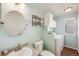 Bathroom featuring a washer, dryer, mounted cabinets, and a round mirror at 9377 Weeping Willow Ct, Highlands Ranch, CO 80130