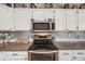 Close up of kitchen features including stainless oven/microwave and granite countertops at 9377 Weeping Willow Ct, Highlands Ranch, CO 80130