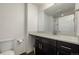 Modern bathroom features a granite countertop, sleek dark cabinets, and a bright mirror at 619 Brennan Cir, Erie, CO 80516