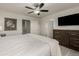 Modern bedroom with a comfortable king-size bed, dresser and large television at 619 Brennan Cir, Erie, CO 80516
