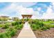Lush community garden with wooden pergola, walking path, and verdant landscaping at 619 Brennan Cir, Erie, CO 80516