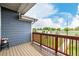 Spacious deck area with wood flooring and red railing overlooking the green landscape at 619 Brennan Cir, Erie, CO 80516
