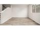 Empty room with wood floors, stairs to the side, and a window in the background at 619 Brennan Cir, Erie, CO 80516